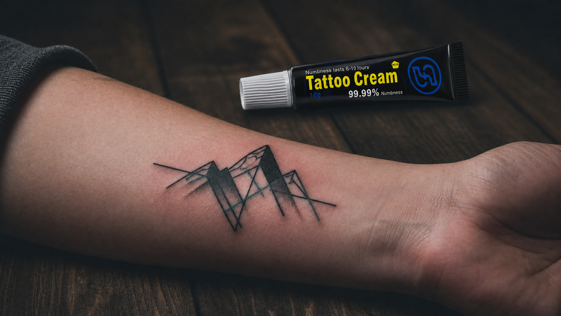 Close-up of a geometric tattoo on forearm with a numbing cream tube beside it on a wooden surface