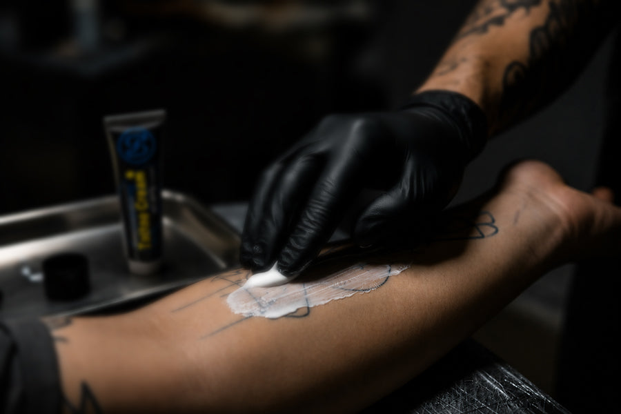 Tattoo artist applying Perfso numbing cream with epinephrine before a tattoo session